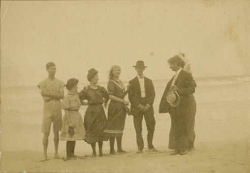 Six people standing on the beach