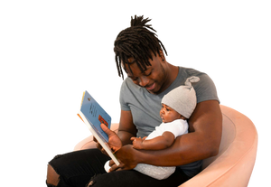 man is reading a book to his baby