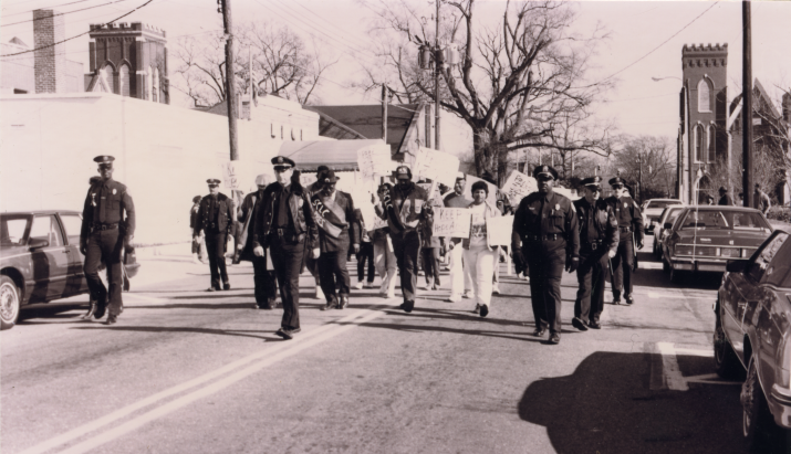 A group of SCLC members, surrounded by a police escort, march through downtown Goldsboro