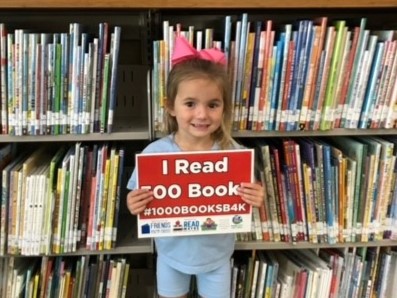 Ellery holding the sign that says she has read 500 books.